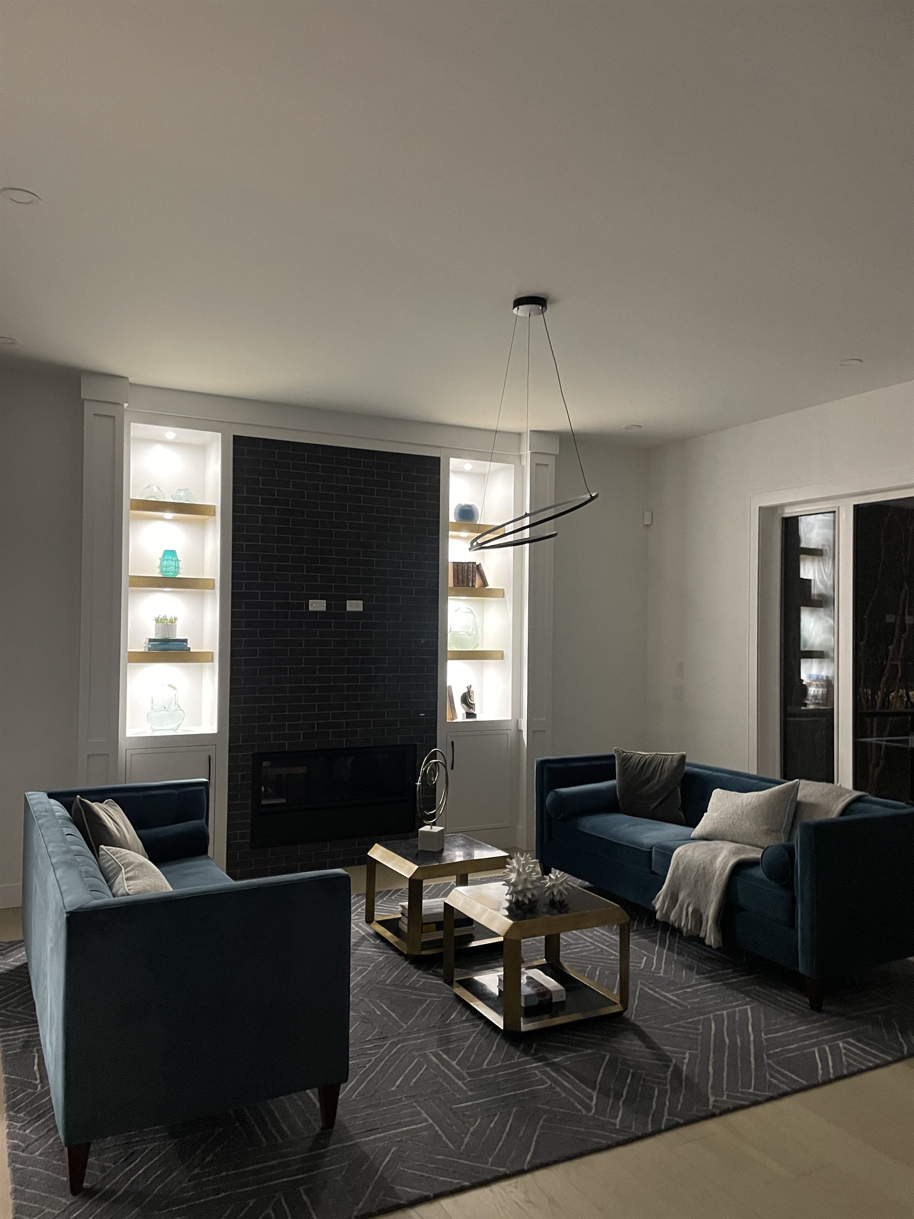 Media room with navy sofas and a black brick fireplace
