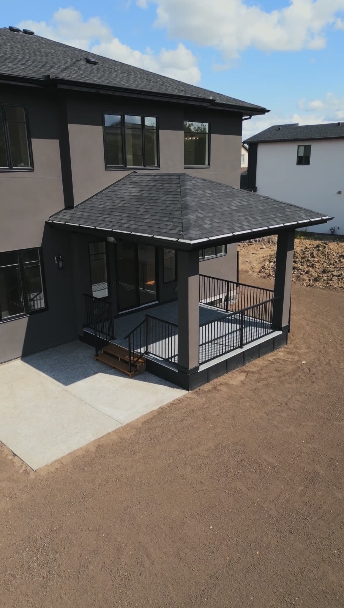 Rear elevation with a covered deck and stone detailing
